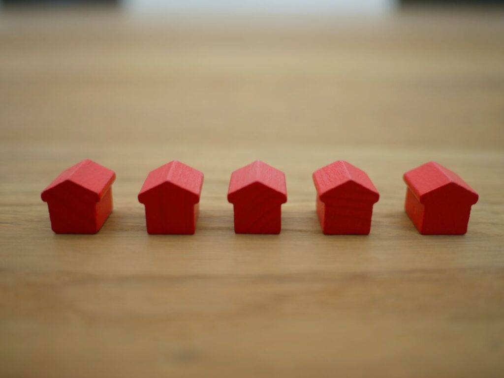 a row of five toy wooden houses on a table