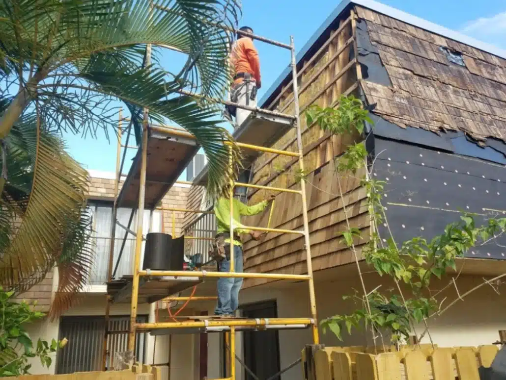 Roofer working on scaffolding during a roof installation on a home.