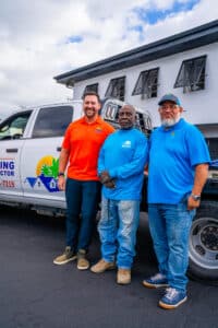 My Florida Roofing Contractor team members standing beside a branded company truck outside the Vero Beach office