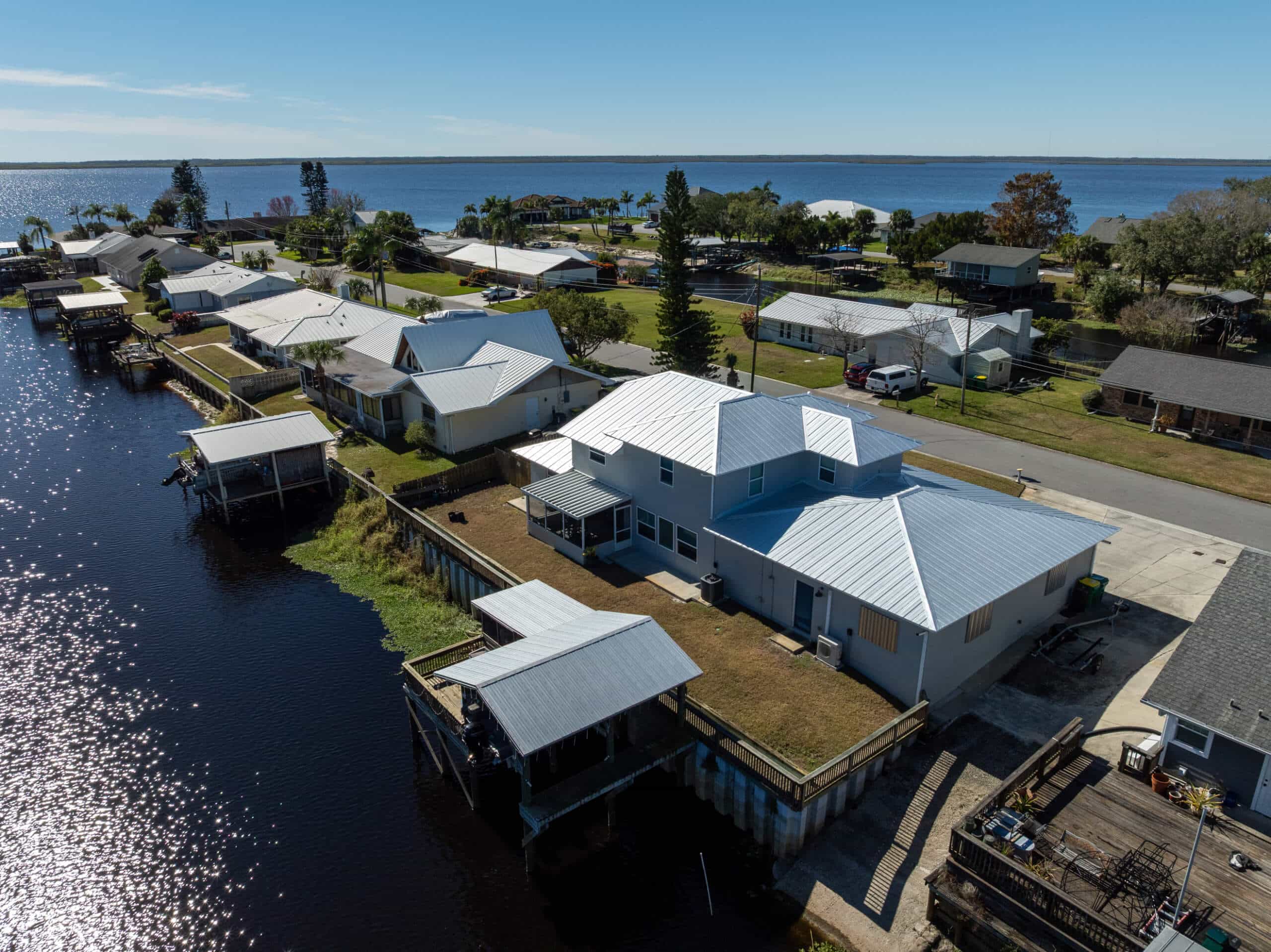 Aerial view of completed metal roof replacements on waterfront homes in Florida