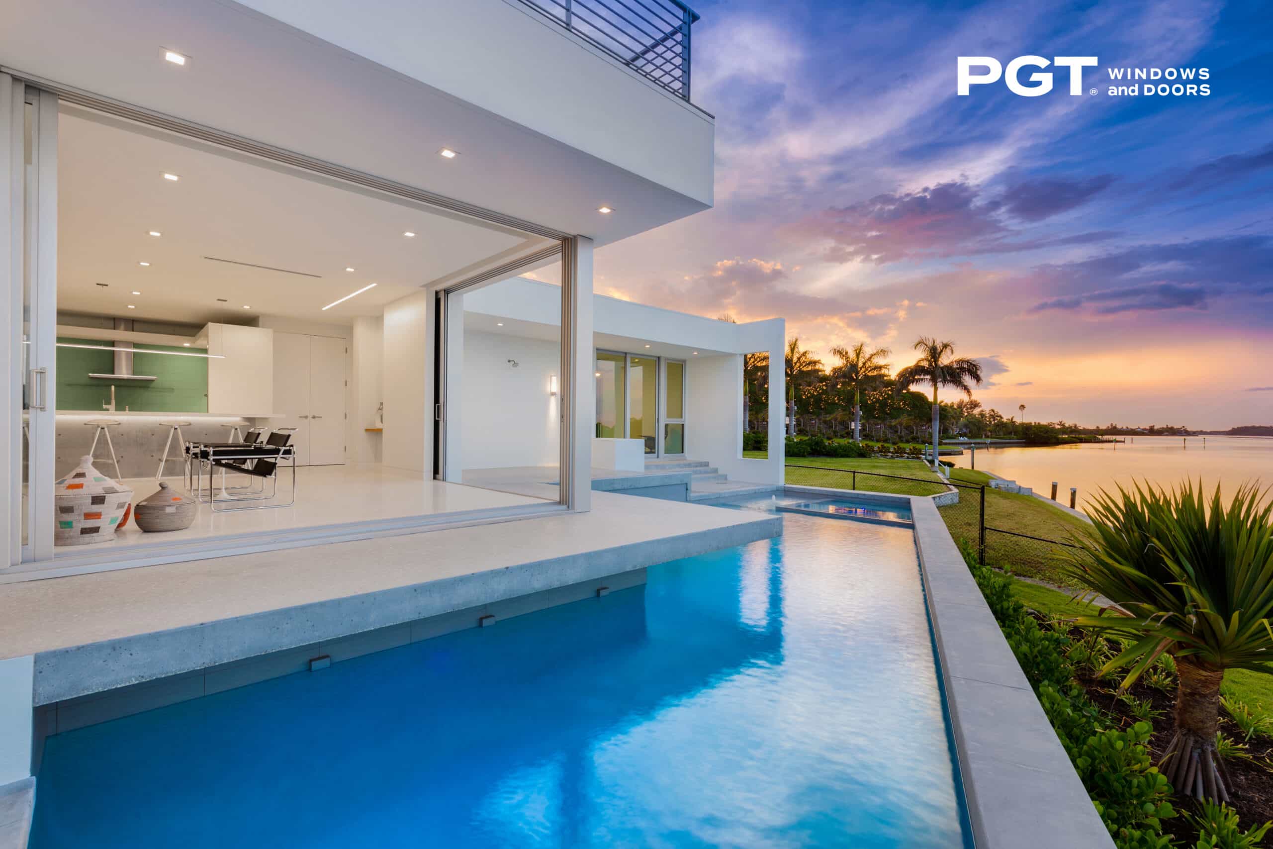 modern multi panel sliding accordion patio door on modern white home with pool in backyard