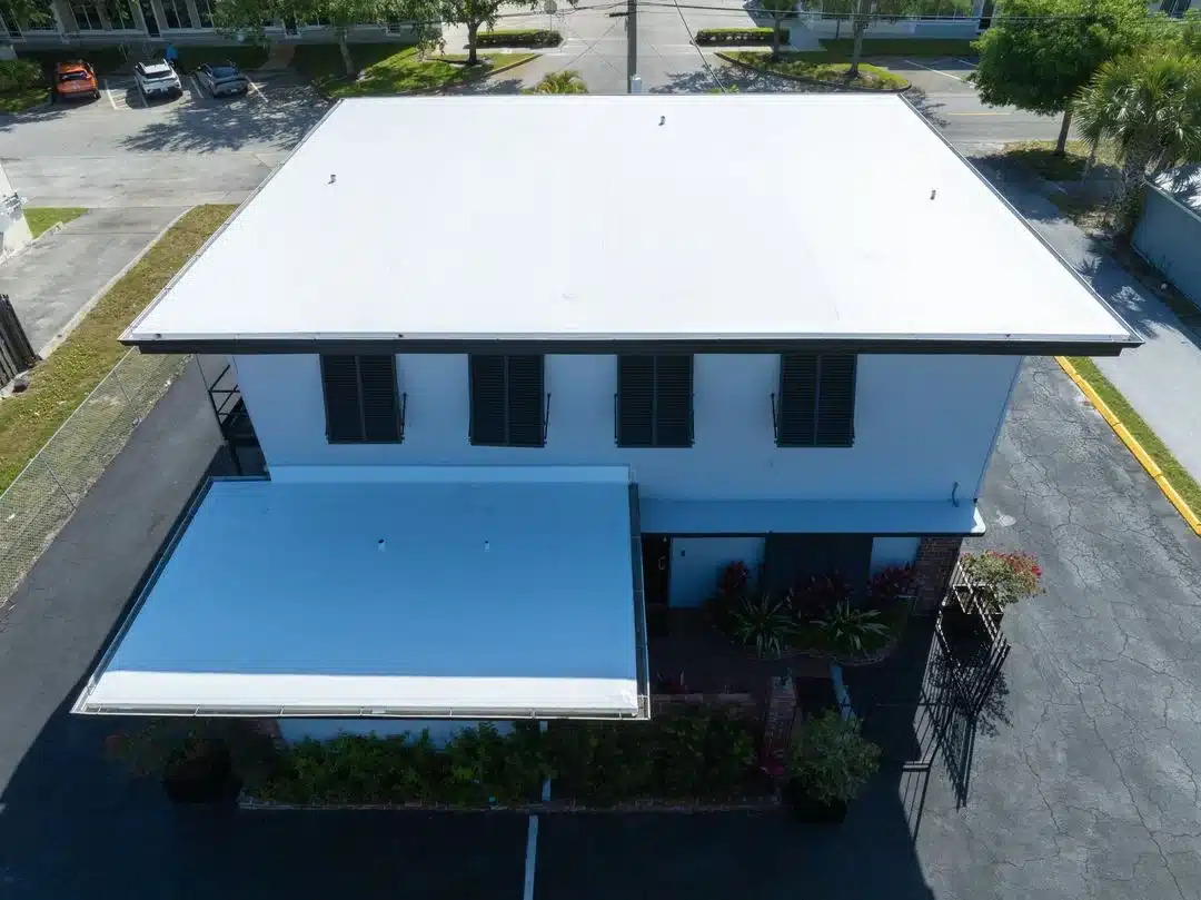 Aerial view of a completed white flat roof replacement on a commercial building in Florida