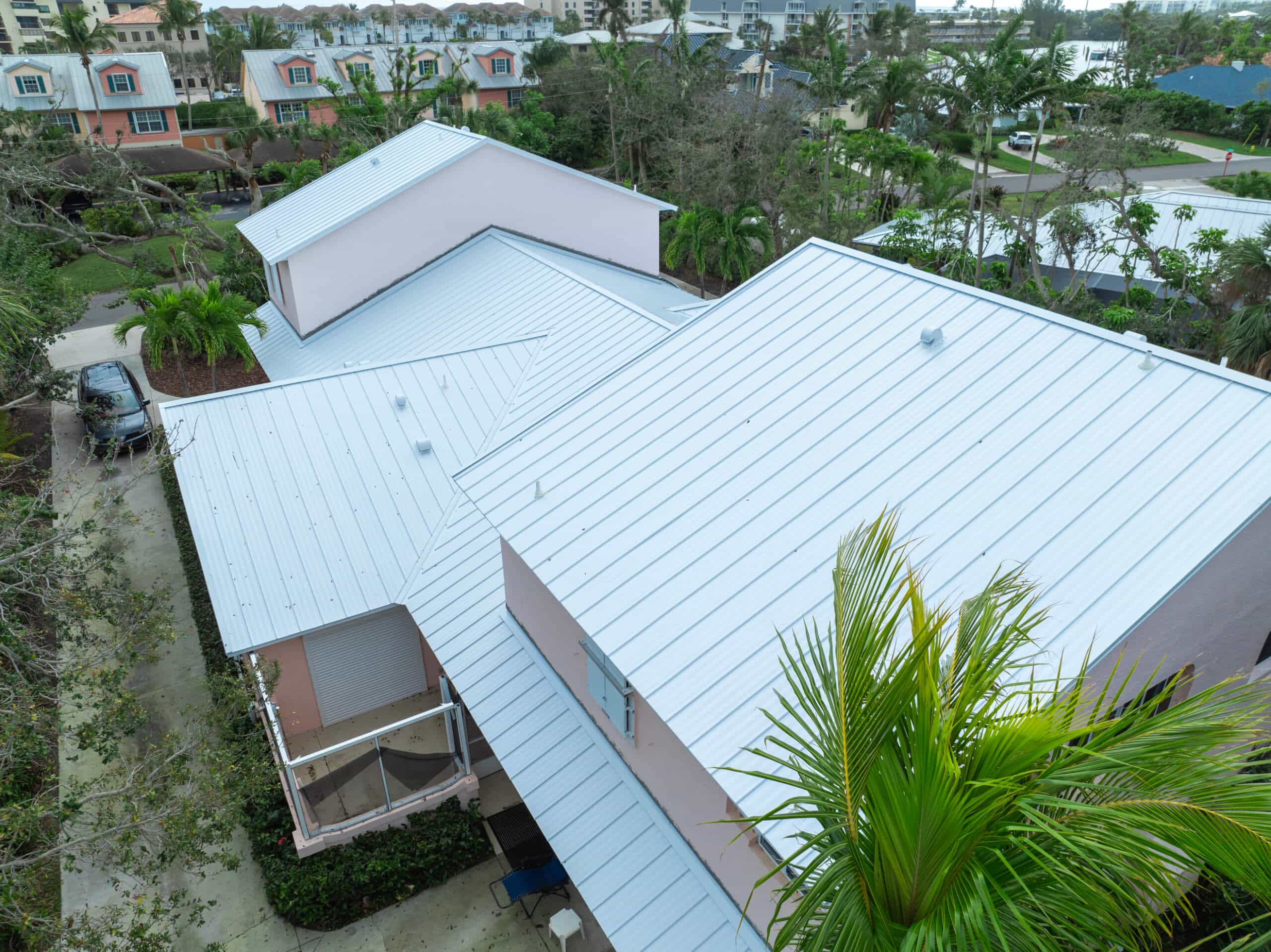 Aerial view of a completed white metal roof replacement on a Florida home