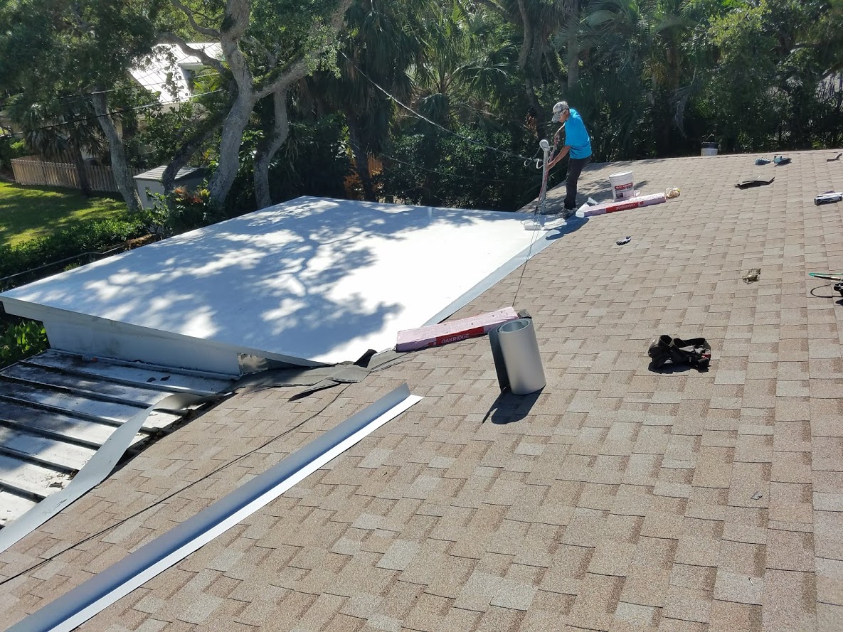 Roofing contractor applying a white protective coating during a flat roof repair in Vero Beach, FL