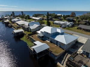 Aerial view of completed metal roof replacements on waterfront homes in Florida