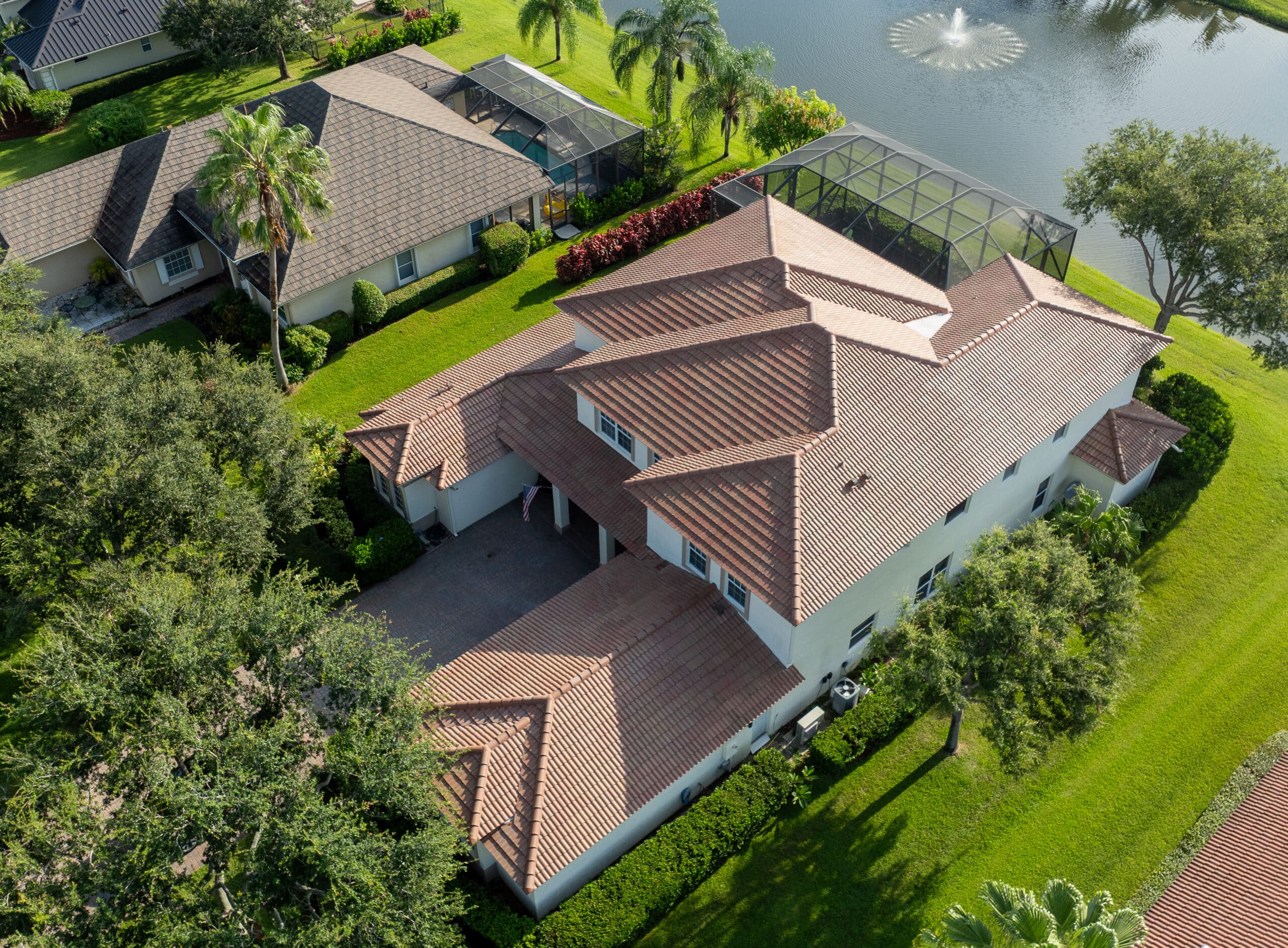 newly replaced tile roof with drone view of home backing up to a pond