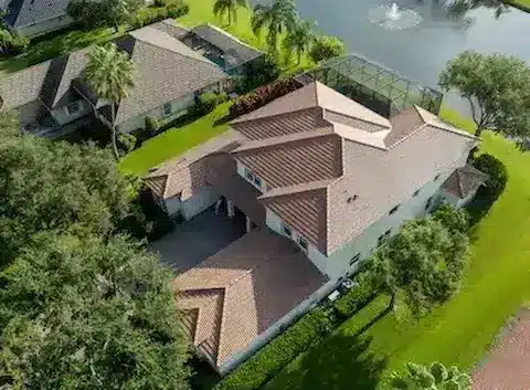 Newly replaced tile roof with drone view of home backing up to a pond